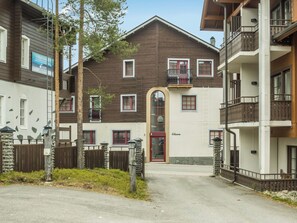 Un edificio de varios pisos con una entrada central, balcones y fachada de piedra.