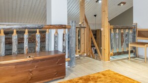 Un intérieur rustique avec des poutres apparentes, un banc en bois et une commode en bois.
