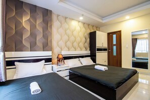 A hotel room with two beds, a nightstand, a lamp, a wardrobe, and a mirror. - The Local Home (Ho Chi Minh City)