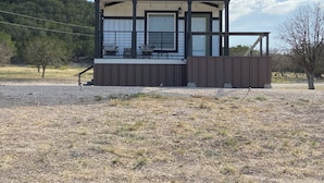 A modern two-story building with a covered porch and large windows.