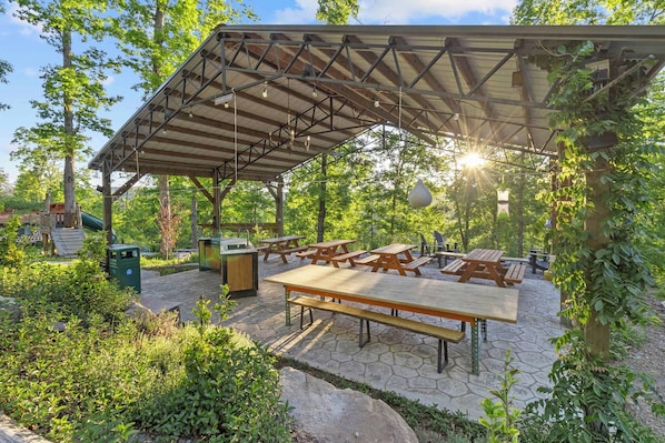 An outdoor patio with picnic tables and a covered seating area.