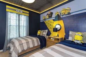 A bedroom with two beds, a brick-patterned wall, and Minion-themed decor. - Luxury, Cozy w/ private pool - FREE RESORT - 4Bed/3Bath 10minutes from Disney (Kissimmee)