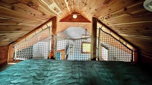 An attic bedroom with wooden beams, a sloped ceiling, and a bed. - Whippoorwill: Cozy Mountain Escape w/ Stargazing Shower & Trails (Marion County)