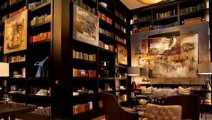 A library in a lobby with bookshelves, a large painting, and seating areas. - 2 BR 2 BA Unit in Vail Village Beautiful Sebastian Residence w 5 Star Amenities (Vail)