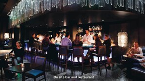 An on-site bar and restaurant with a modern interior, including hanging crystal chandeliers and a bar area with patrons. - 2 BR 2 BA Unit in Vail Village Beautiful Sebastian Residence w 5 Star Amenities (Vail)