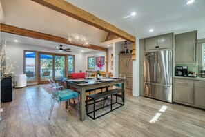 A spacious kitchen with wooden beams, a large stainless steel refrigerator, and a dining area with a bench and chairs. - Views! Private! Tranquil! Lakefront! Forest! Sunsets! Acreage! Docks! (Lower Lake)