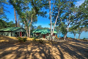 A cabin with a green roof, surrounded by trees and a lake. - Views! Private! Tranquil! Lakefront! Forest! Sunsets! Acreage! Docks! (Lower Lake)
