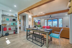 A modern kitchen with wooden beams, a dining table with chairs, and a view of the outdoors through large windows. - Views! Private! Tranquil! Lakefront! Forest! Sunsets! Acreage! Docks! (Lower Lake)