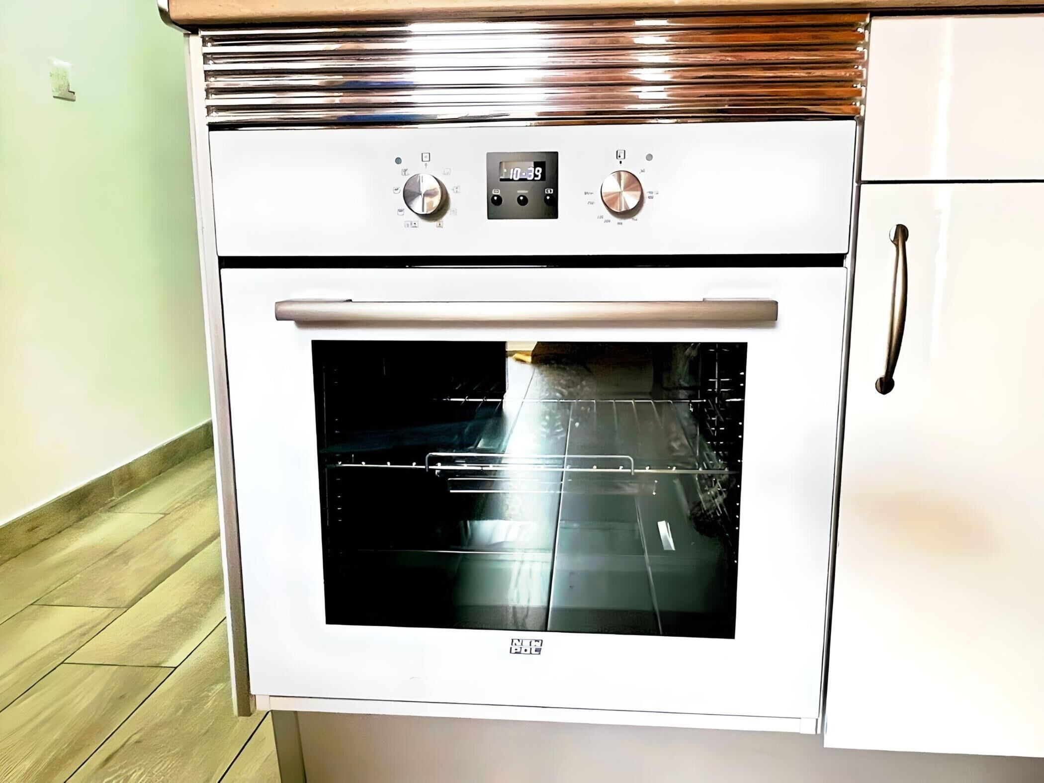 A white oven with a digital display and two control knobs.