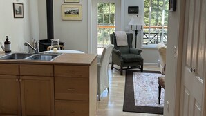 Una cocina moderna con una isla central, una campana extractora negra y vistas al exterior a través de un ventanal grande.