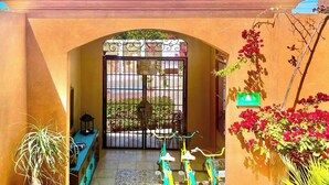 A courtyard with a gate, potted plants, and bicycles. - Dreamy Condo in Centro Histórico + Unlimited Pool Club Access! (Todos Santos)