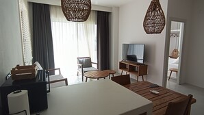 A modern hotel room with a dining area, a TV, and a large window with curtains. - Gizz Suites City (Fethiye)