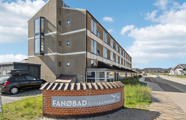 A modern building with a brick base and a glass facade, labeled "Fanobad FerieleLjigheder." - 1 bedroom awesome apartment in Fanø (Fanø)