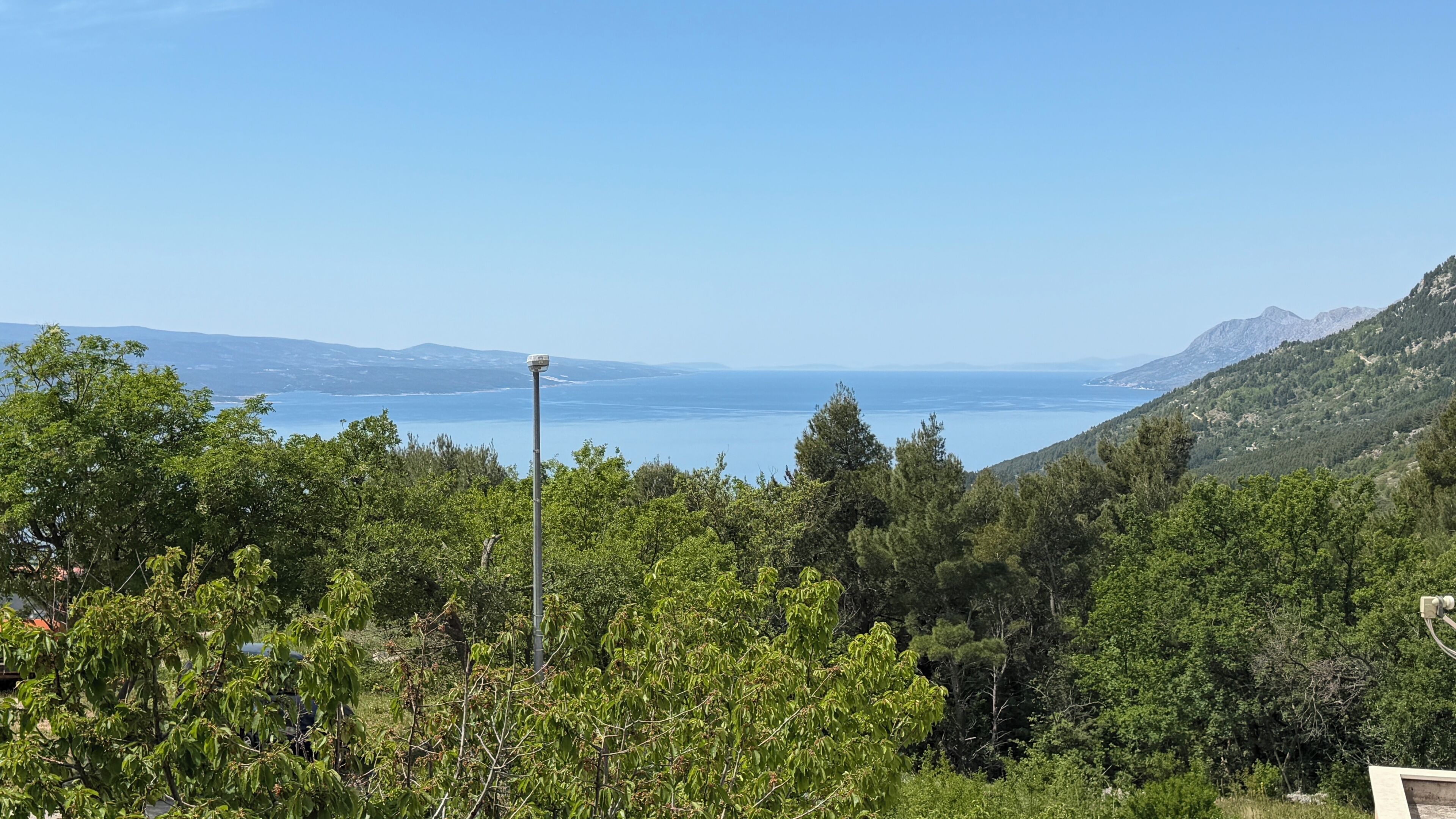 Un paysage montagneux, caractérisé par une végétation luxuriante et une vue dégagée sur la mer.