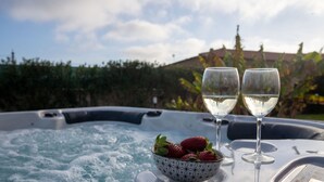 Ein Whirlpool mit zwei Gläsern Weißwein und einer Schale Erdbeeren.