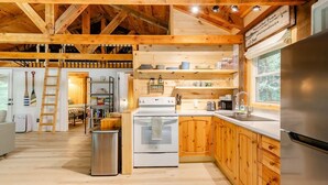 A cozy kitchen with wooden cabinets, a stainless steel refrigerator, and a built-in oven.