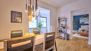 Een moderne eetruimte met een houten tafel, gestreept beklede stoelen en hanglampen.