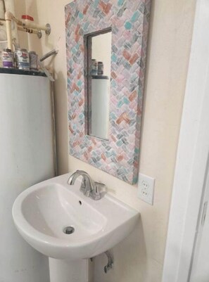 A bathroom with a white sink, a mirror with a herringbone tile backsplash, and a toilet. - Serenity! a Gateaway from long stressfull hours to a Peacefull Calm Retreat (Naples)