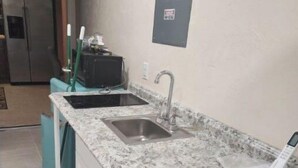 Eine Küche mit Granit Arbeitsplatten, einer Edelstahl-Spüle und einem eingebauten Backofen.