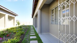 A narrow pathway flanked by a garden with stepping stones and various plants. - Minilitha Lodge (Richards Bay)