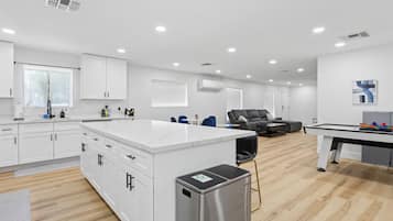 A modern kitchen with white cabinets, a stainless steel refrigerator, and a central island.