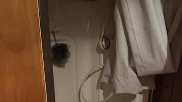 Een douche, handdoeken, zeep, toiletpapier