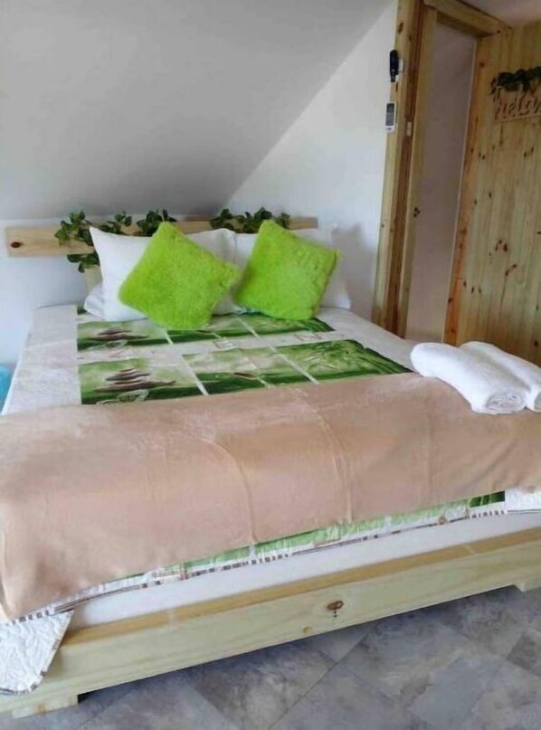 A bed with a green and white patterned bedspread, two green pillows, and a white towel. - Villa ático beach house,pool,wifi,Netflix,backyard (Salinas)