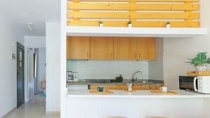 Una cocina moderna con encimera blanca, armarios de madera y dos taburetes.