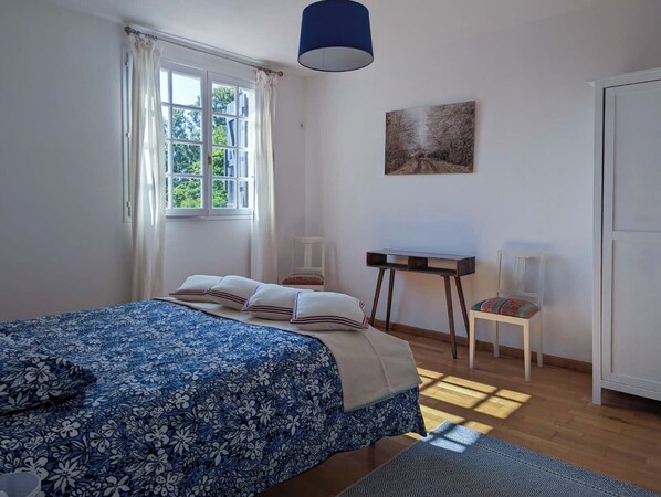 A bedroom with a bed, a desk, a chair, and a wardrobe. - Charming vacation home with a view, private spa, and pool (Monfaucon)