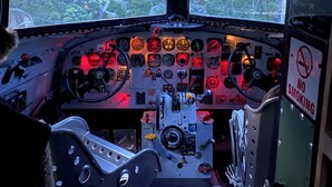 A cockpit with multiple control panels, a steering wheel, and a view of the outside through the windshield. - Stay in a Piece of History! 1941 WWII Douglas DC-3 Airliner (Deerbrook)