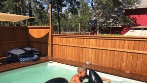 A child riding an inflatable orca in a swimming pool. - Abundant Activities for Adventures People (Goldendale)