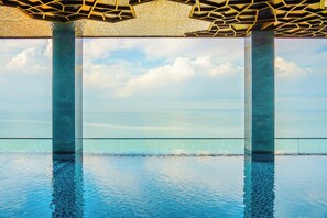 A pool with clear water, surrounded by glass railings and supported by large columns. - Won Majestic Hotel Cambodia (Sihanoukville)