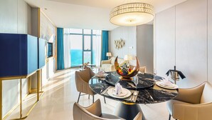 A modern dining area with a marble table, comfortable seating, and a view of the ocean. - Won Majestic Hotel Cambodia (Sihanoukville)