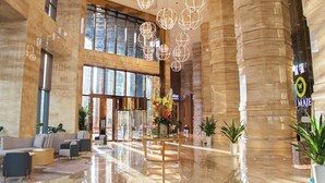A spacious lobby with a polished marble floor, large windows, and a central floral arrangement. - Won Majestic Hotel Cambodia (Sihanoukville)
