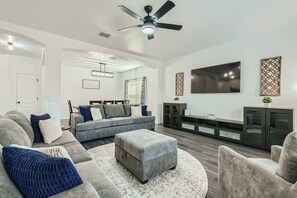 Relax in this stylish living room with a grey sofa, flat-screen TV, and large window.