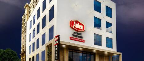 A modern hotel with a prominent 'Aiden' sign, a 'Best Western' logo, and a 'Mamarom' sign.