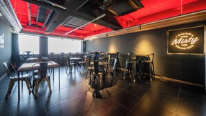 A modern dining area with tables and chairs, a neon sign, and a red ceiling. - Haeundae Dongbeck Hotel (Busan)