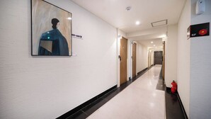 A hotel corridor with a framed artwork on the wall, a fire extinguisher, and a sign indicating room number 6F. - Haeundae Dongbeck Hotel (Busan)