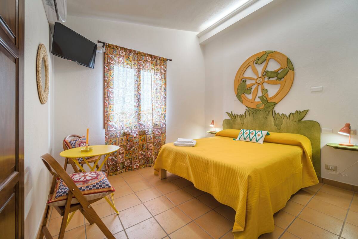 A room with a bed, a small table, and a chair.