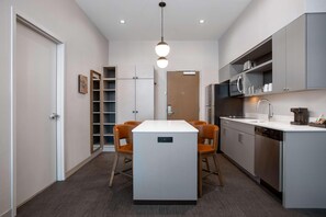 A modern kitchen with a central island, built-in appliances, and a dining area with chairs. - Homewood Suites by Hilton Missoula (Missoula)