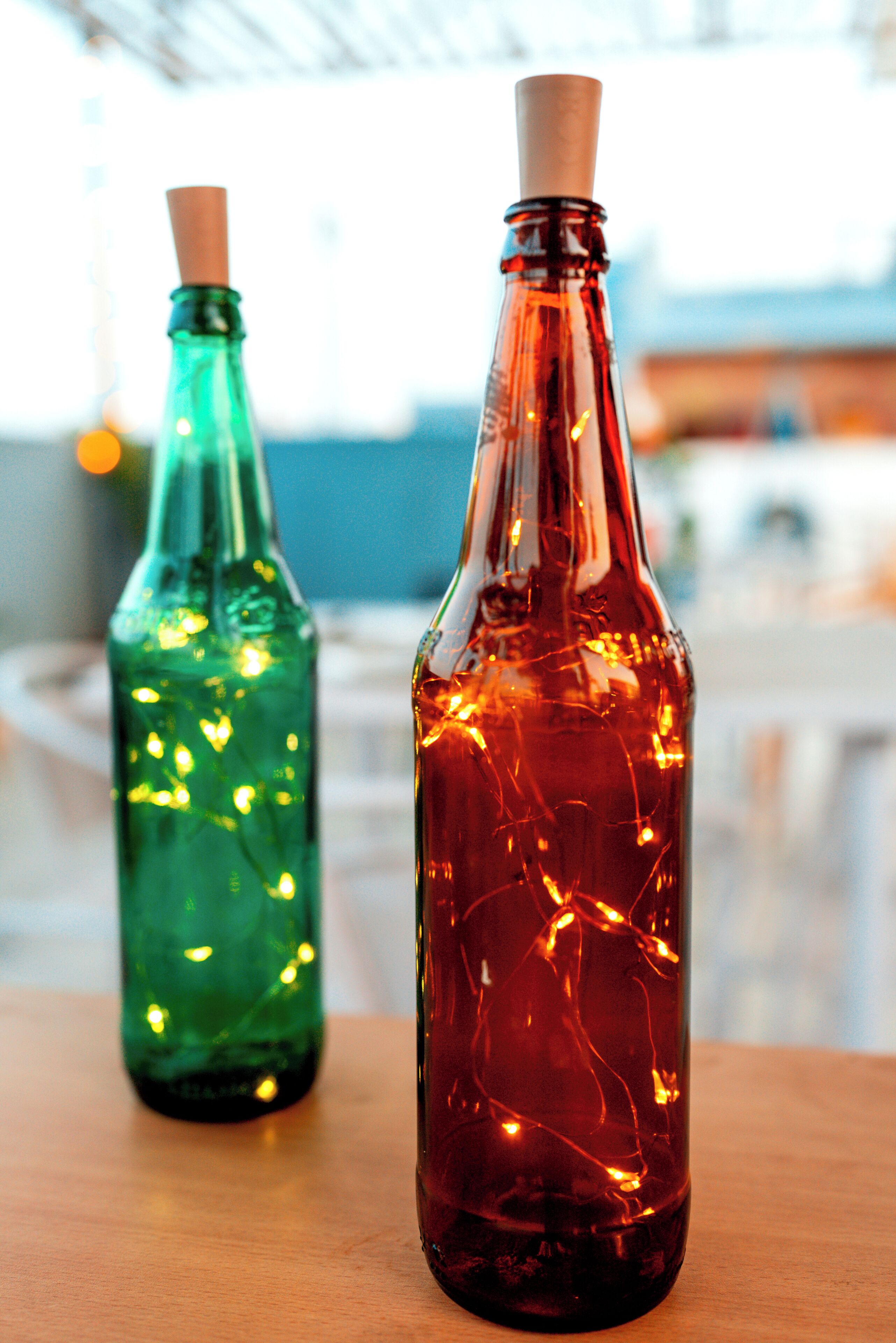 Two glass bottles with cork stoppers on a wooden surface.