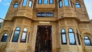 A multi-story building with intricate architectural details, featuring a prominent entrance with a sign reading "Hotel Jodhpur Regency." - Hotel Jodhani Regency (Jaisalmer)