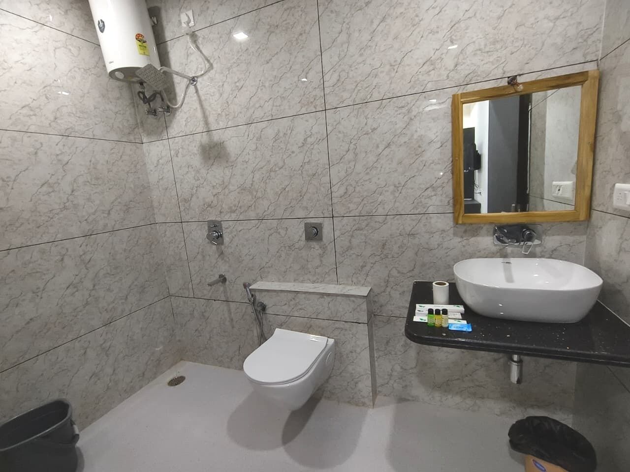 Een badkamer met toilet, wastafel en spiegel.
