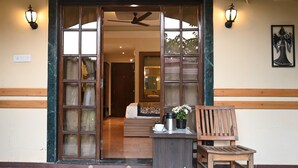 A hotel entrance with a wooden bench, a coffee table, and a potted plant. -  Woods Inn Resort (Airport Hotel) (Bhopal)
