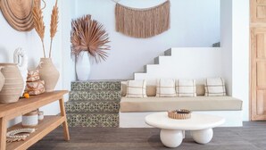A modern living room with a sofa, a coffee table, and decorative items like vases and a macrame wall hanging. - Villa Madissa by Villa Finder (Canggu)
