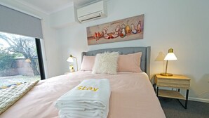 Une chambre d’hôtel avec un lit, une serviette «pour les clients», un tableau, deux lampes de chevet et une fenêtre.