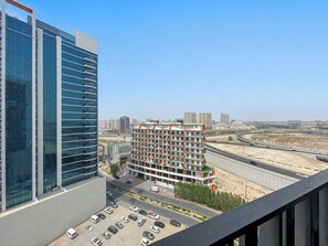 Un edificio alto con facciata in vetro moderna e un parcheggio con diverse auto.