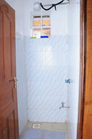 Chuveiro, toalhas de banho, sabonete, papel higiênico