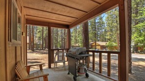 Un espacio al aire libre techado con una parrilla y una silla.