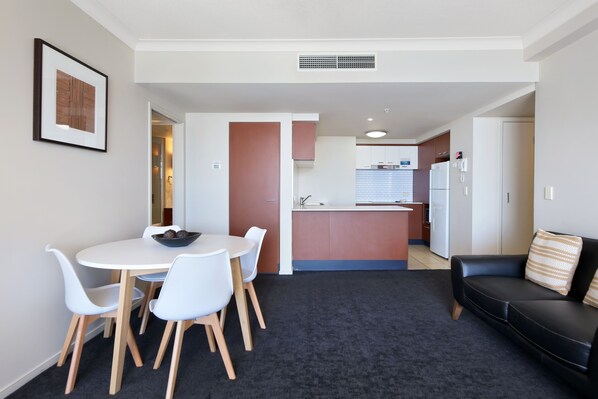 A modern apartment with a dining area, kitchen, and living space.